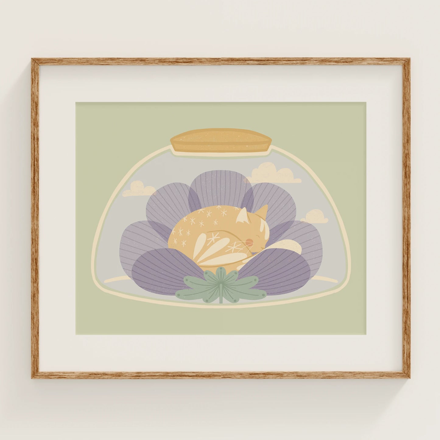 'a nap or two' art print, shown in a wood frame. print features cat sleeping inside of a flower, inside of a jar.