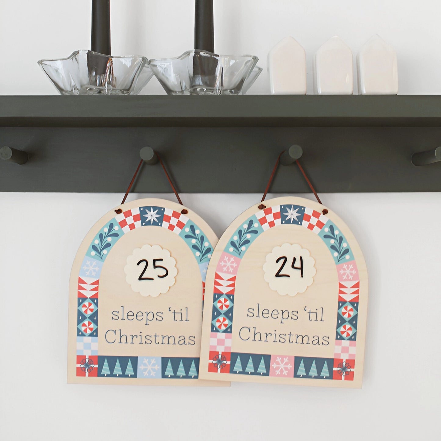 two wood countdown sign with 'sleeps 'til Christmas' text and decorative patterns shown hanging on the wall