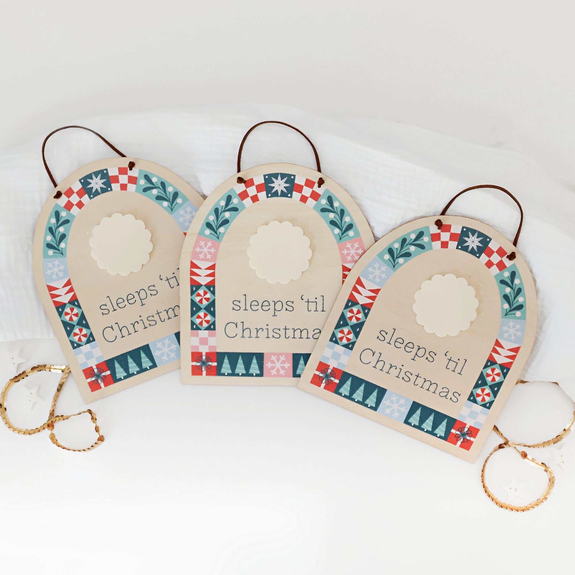 three wood countdown sign with 'sleeps 'til Christmas' text and decorative patterns shown on a white background