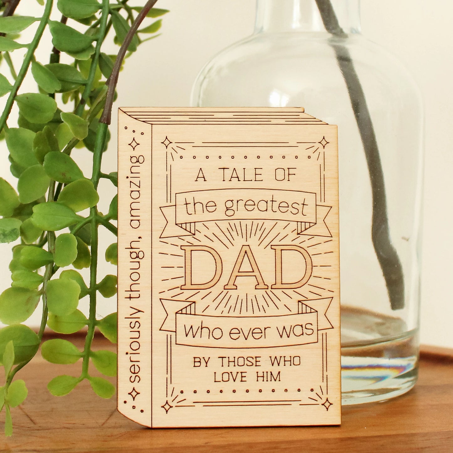 mini wood book shaped card. cover text reads 'a tale of the greatest dad who ever was by those who love him' and spine text reads 'seriously though, amazing'