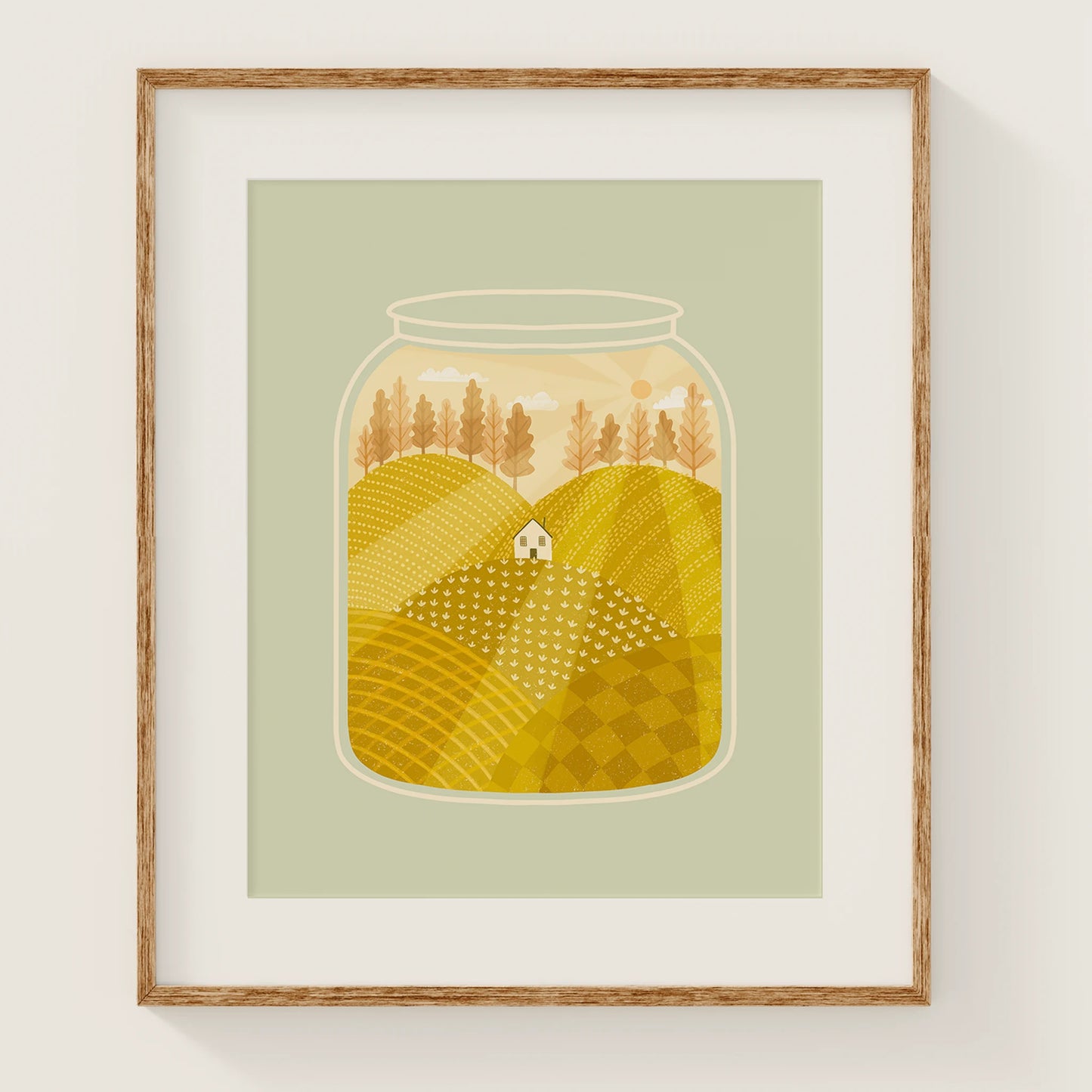 'going home' art print, shown in a wood frame. print features a small white house nestled among yellow fields during a peach sunset, inside of a jar.