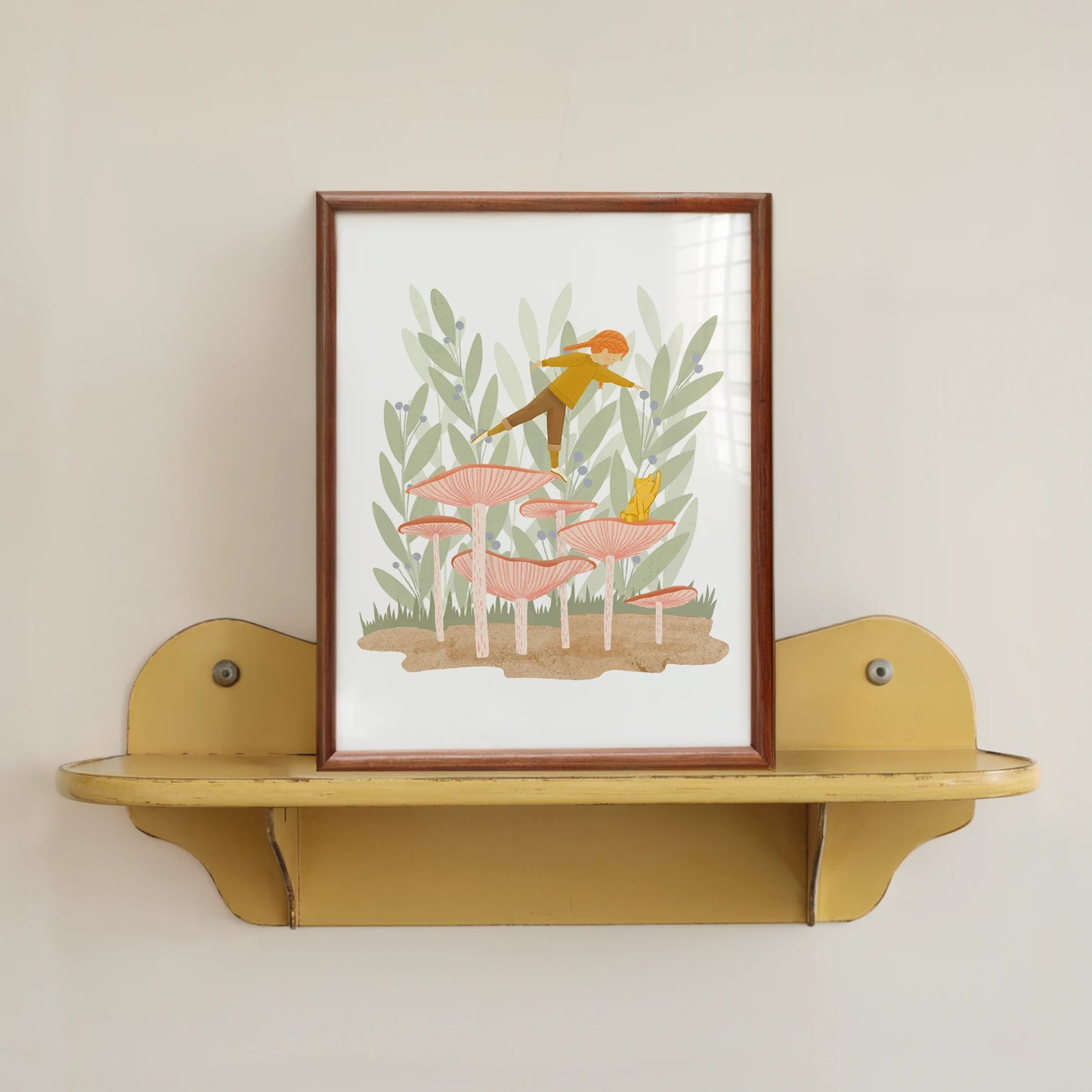leaning in art print, shown in a wood frame on a yellow shelf. print features a girl, balancing on one foot on a mushroom with a cute cat nearby.