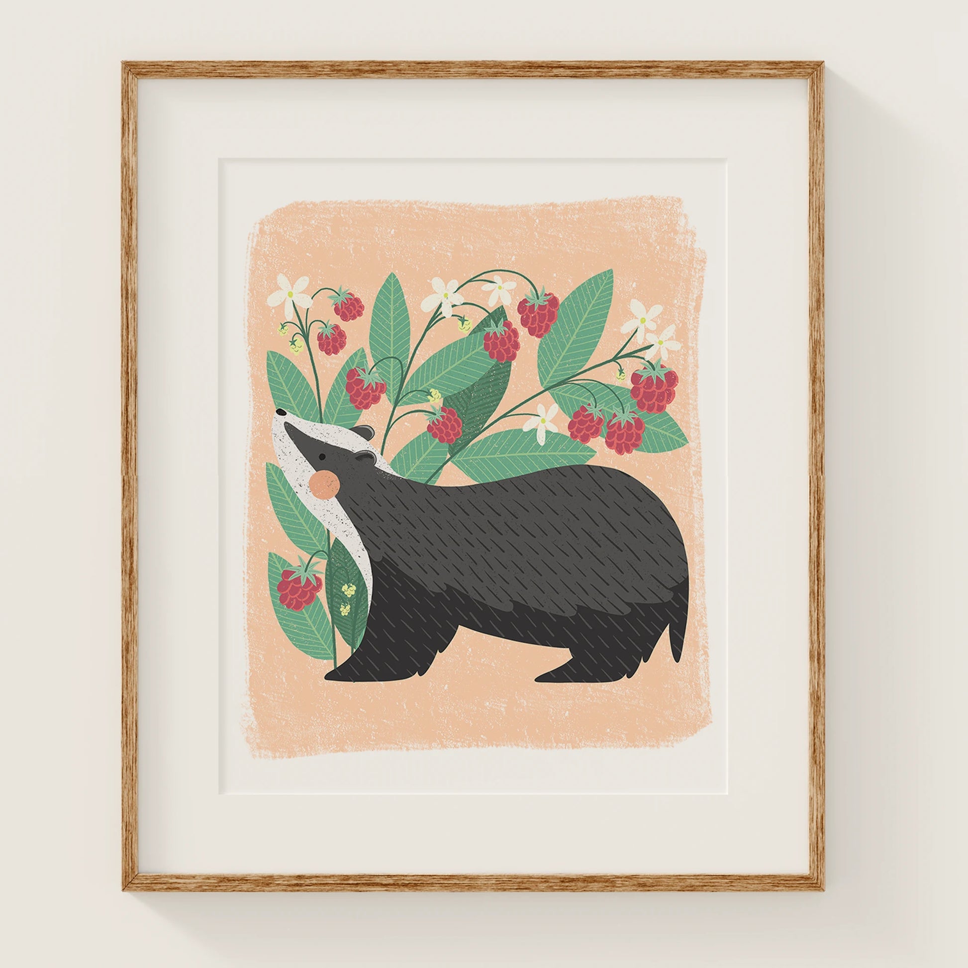 'berry bandit' art print, shown in a wood frame. print features a whimsical badger in front of a cute raspberry plant.