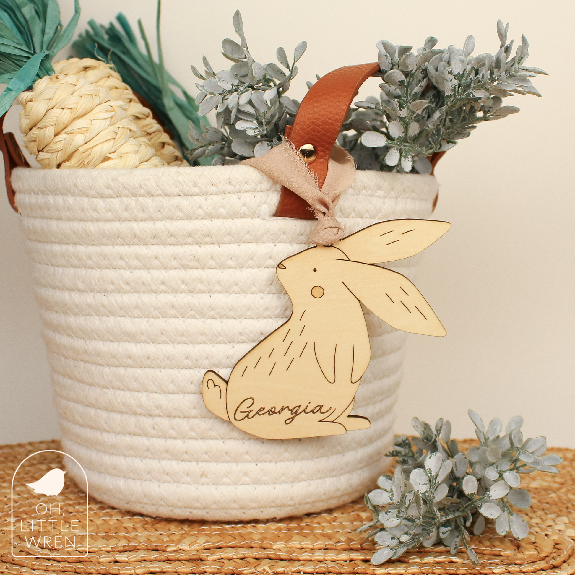 wooden easter bunny tag in birch wood tone with the name georgia, shown hanging from a white rope basket.