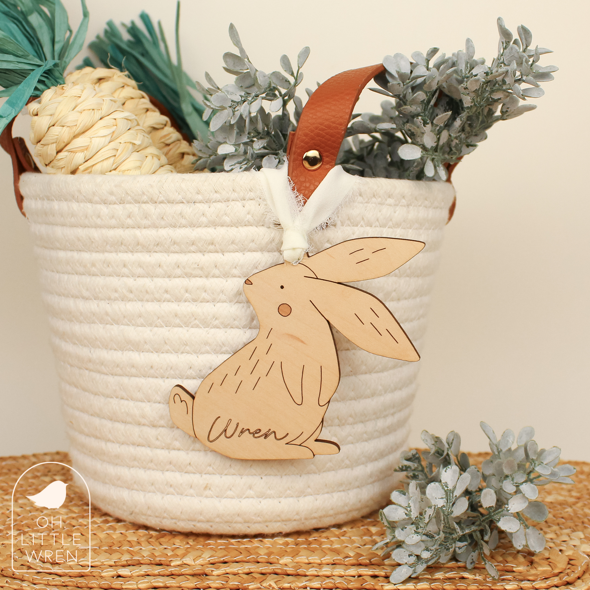 wooden easter bunny tag in maple wood tone with the name Wren, shown hanging from a white rope basket.
