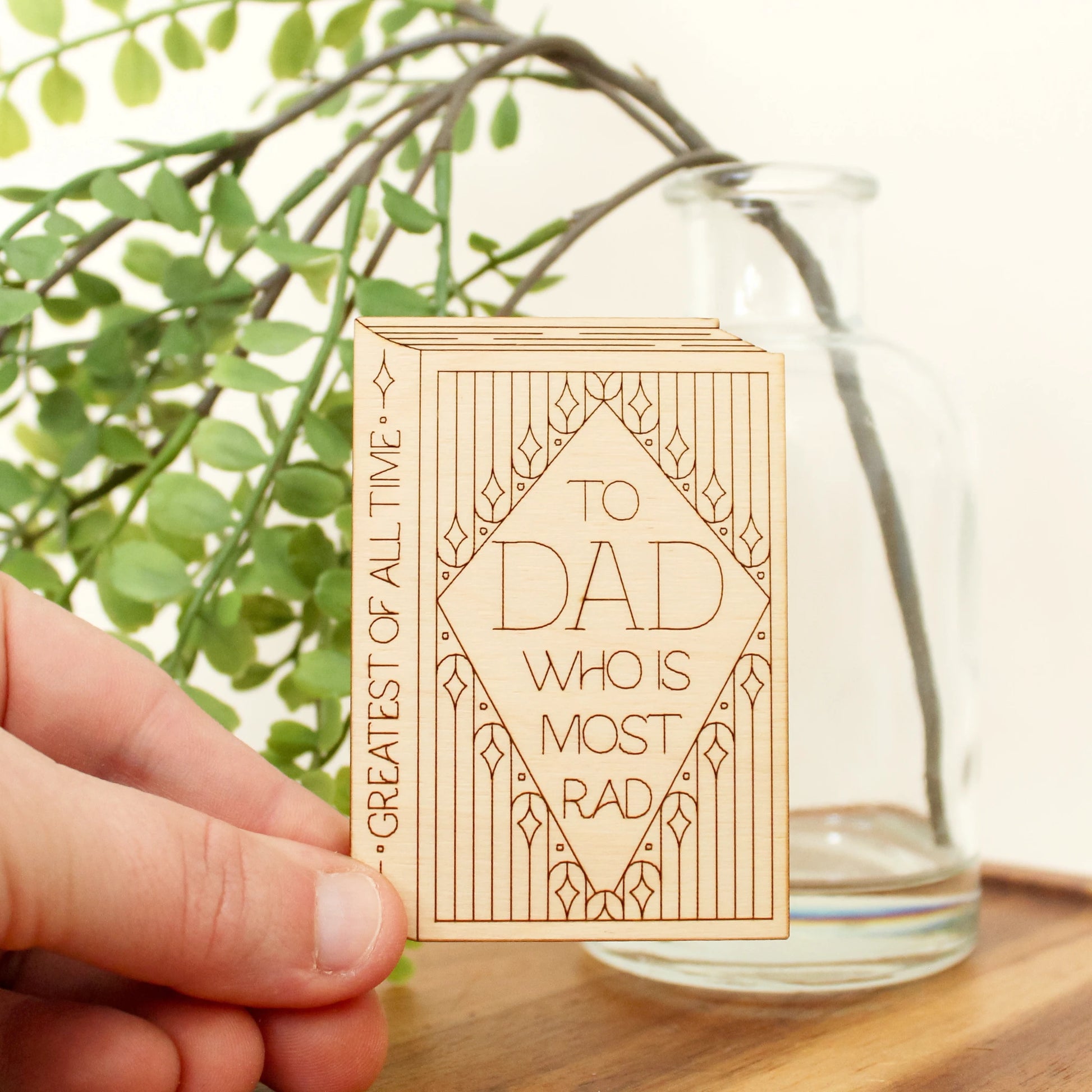 mini wood book shaped card. cover text reads 'to dad who is most rad' and spine text reads 'greatest of all time'