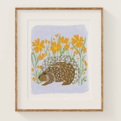 'flower frolic' art print, shown in a wood frame. print features a whimsical porcupine in front of orange flowers.