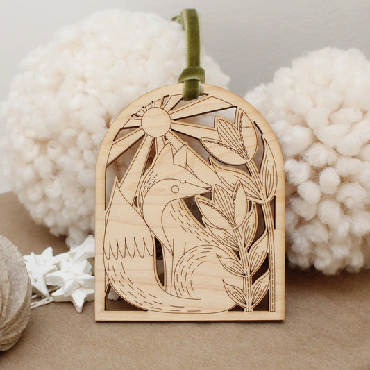 wooden fox arch shaped ornament with etched flowers and a sunshine.