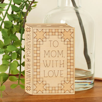 wooden book shaped card with quilt motifs. cover reads 'to mom with love'. spine reads 'always & forever'.