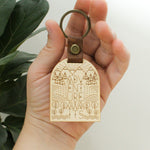 load image into gallery viewer, wooden keychain for the adventure lover. design has mountains, trees, fields and streams and the words &#39;adventure awaits&#39;.  wooden keychain with leather strap and bronze colored hardware.

