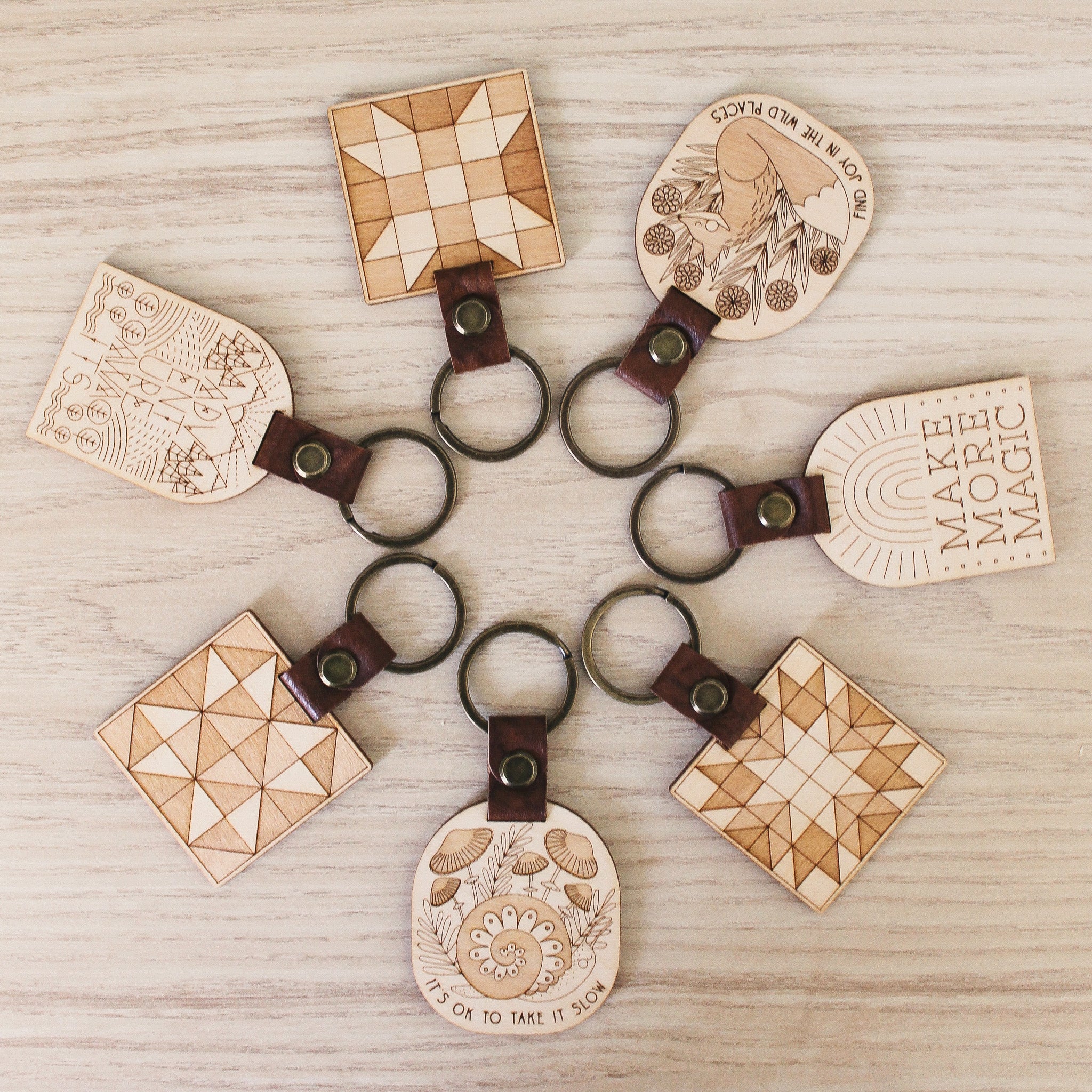 assorted wooden keychains with leather straps and bronze hardware.