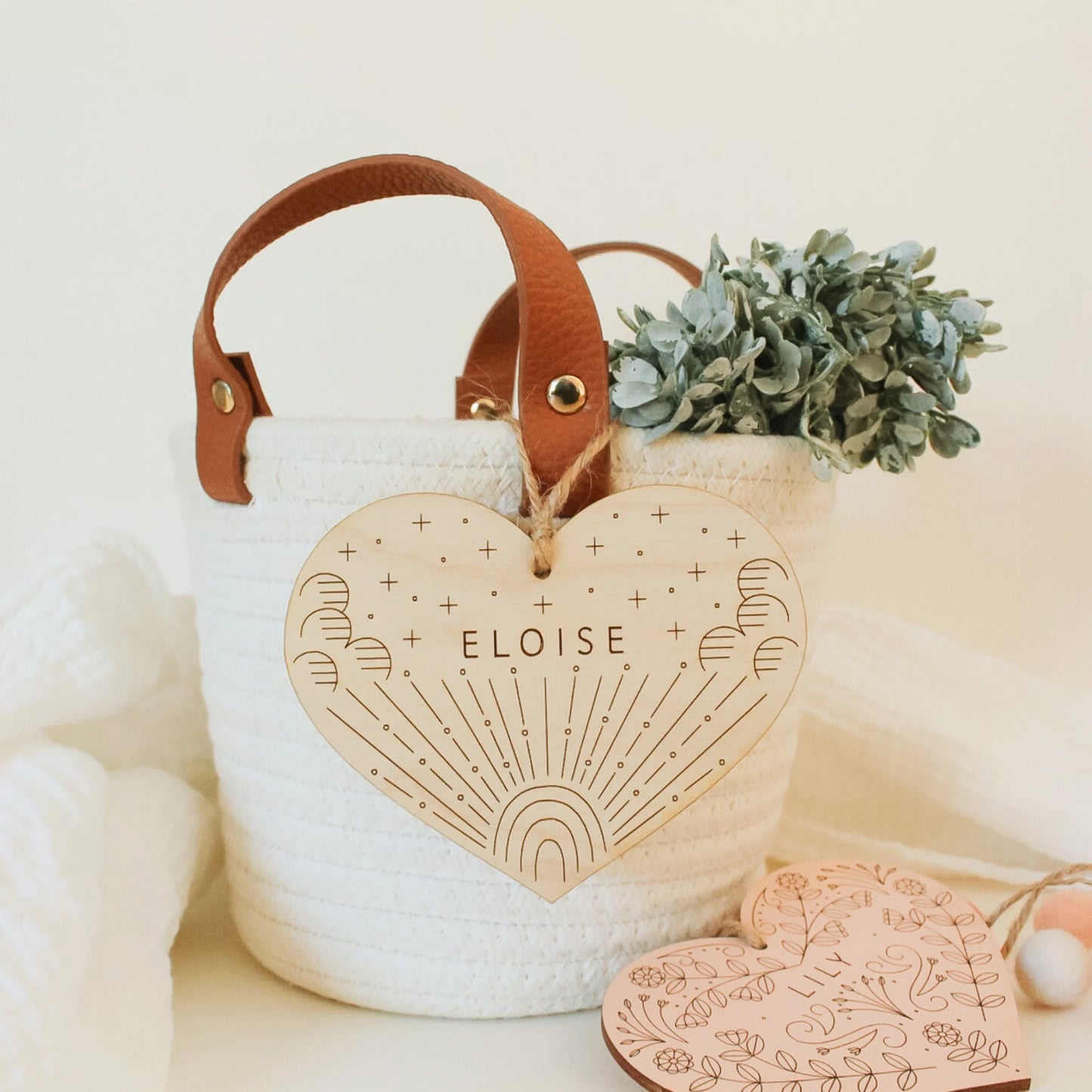 natural wood heart with etched rainbow and clouds design, shown hanging from a basket. name reads ELOISE