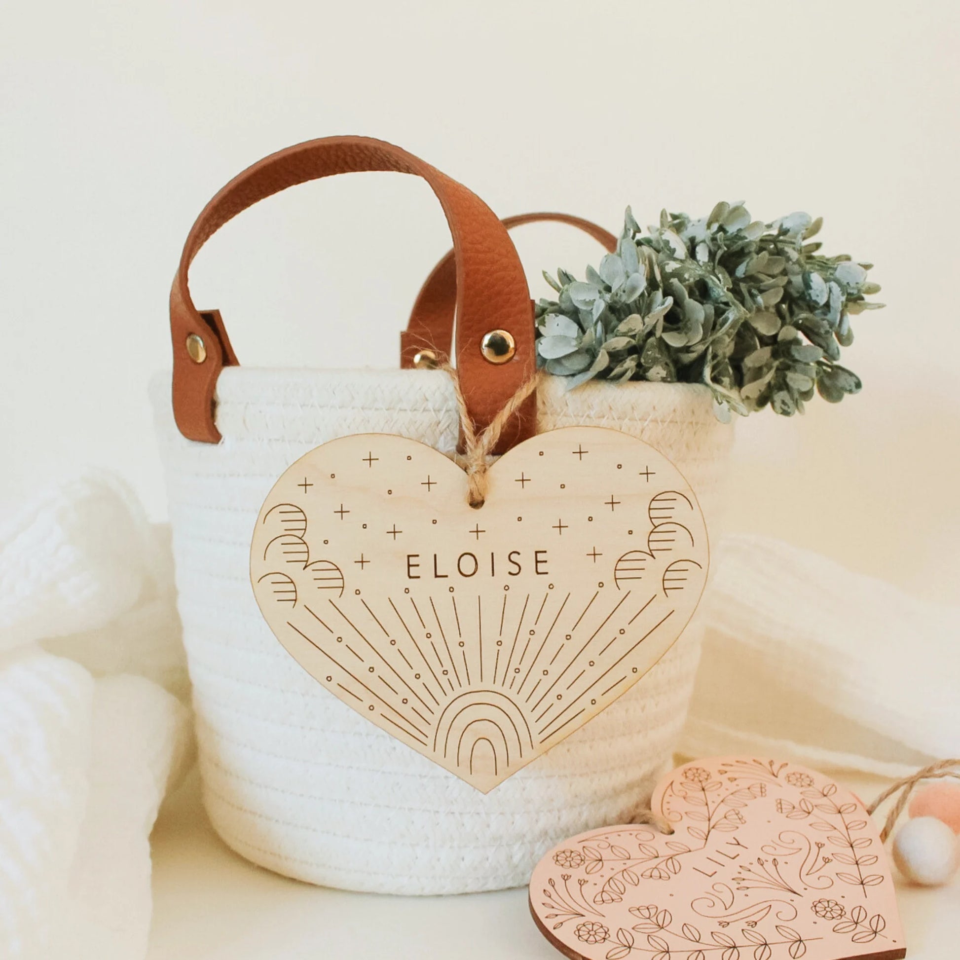 natural wood heart with etched rainbow and clouds design, shown hanging from a basket. name reads ELOISE