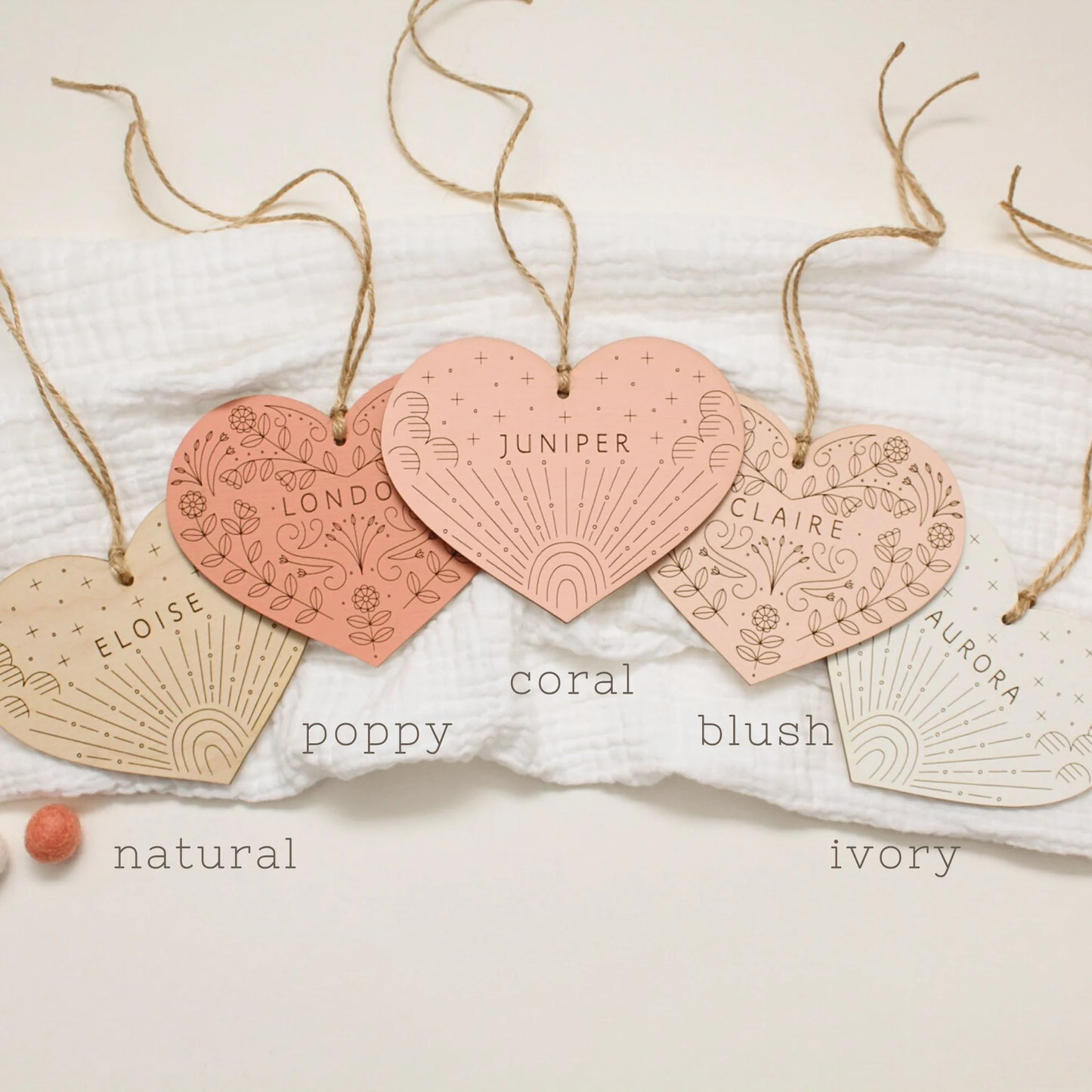 all etched heart color options shown labeled--from left to right: natural, poppy, coral, blush and ivory. designs from left to right are rainbow, floral, rainbow, floral, rainbow.