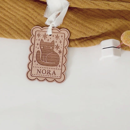 video of personalized halloween tags with ghost and black cat designs being laid down on a table.