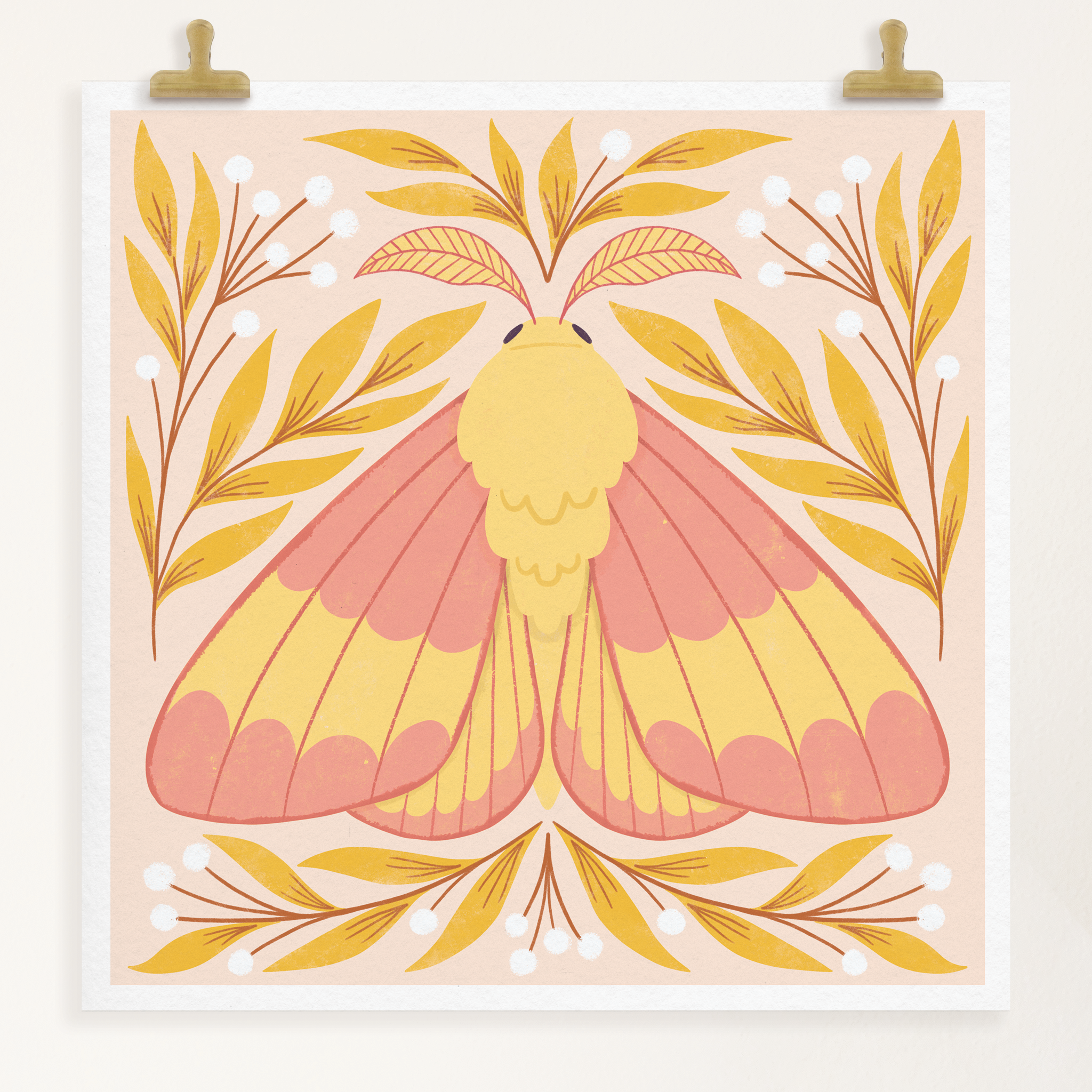 art print showing a rosy maple moth in bright pinks and yellows, surrounded by yellow and white whimsical florals. shown displayed hanging from two gold clips.