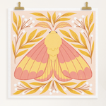 load image into gallery viewer, art print showing a rosy maple moth in bright pinks and yellows, surrounded by yellow and white whimsical florals. shown displayed hanging from two gold clips.
