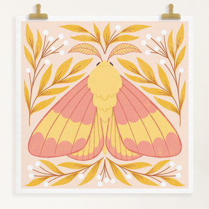 art print showing a rosy maple moth in bright pinks and yellows, surrounded by yellow and white whimsical florals. shown displayed hanging from two gold clips.