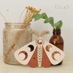 load image into gallery viewer, wooden moth with moon phase design. painted in blush pinks and terracotta reds with wood tones and mirrored rose gold moon phase inlays.
