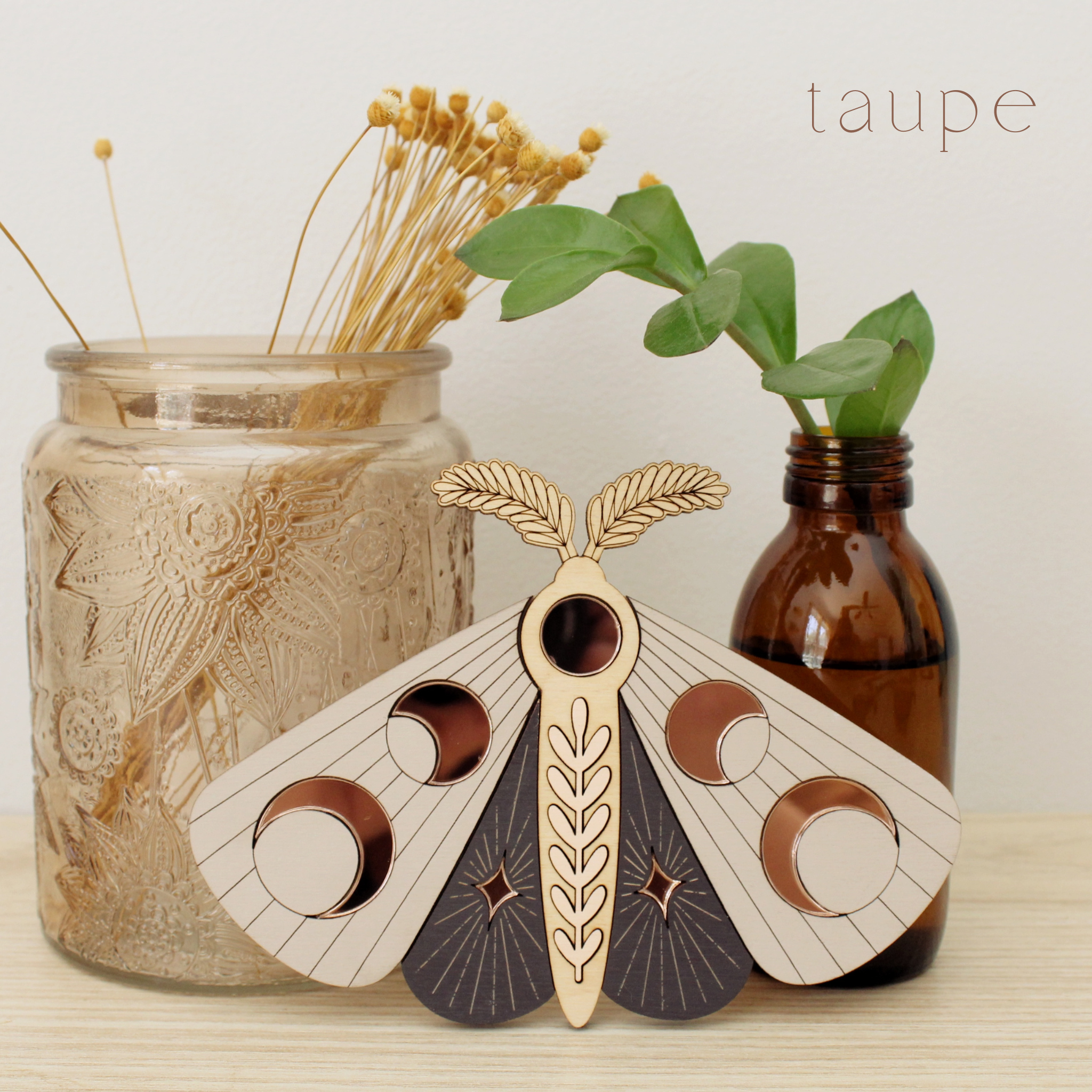 wooden moth with moon phase design. painted in deep plum and taupe with wood tones and mirrored rose gold moon phase inlays.