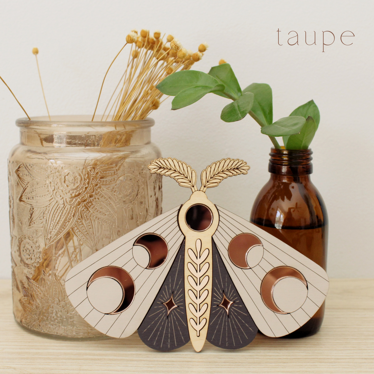 wooden moth with moon phase design. painted in deep plum and taupe with wood tones and mirrored rose gold moon phase inlays.