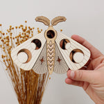 load image into gallery viewer, wooden moth with moon phase design. painted in white and taupe with wood tones and mirrored rose gold moon phase inlays.
