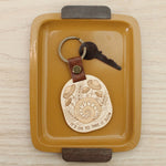 load image into gallery viewer, wooden keychain with snail design surrounded by mushrooms and the text &#39;it&#39;s ok to take it slow.&#39; with leather strap and bronze colored details.
