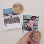 load image into gallery viewer, pair of circular wooden magnets, one with a fox surrounded by flowers and the other with a snail and mushrooms.
