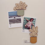 load image into gallery viewer, wooden houseplant magnets shown holding up pictures against a white background.
