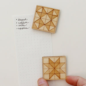 pair of wooden quilt block magnets featuring two different quilt block star designs in a two-toned wood etch.