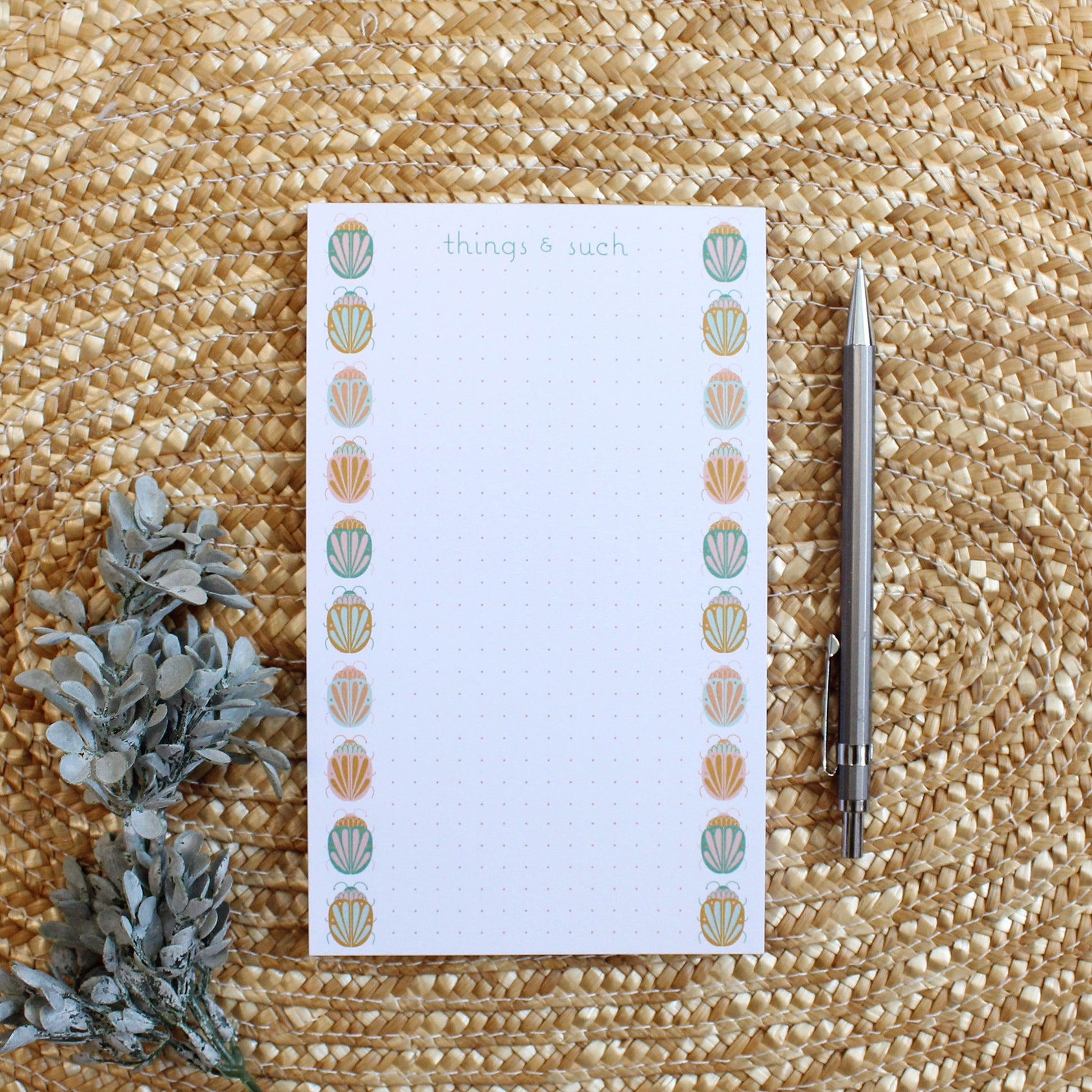 dotted notepad with colorful beetle illustrations going up either side of the paper.