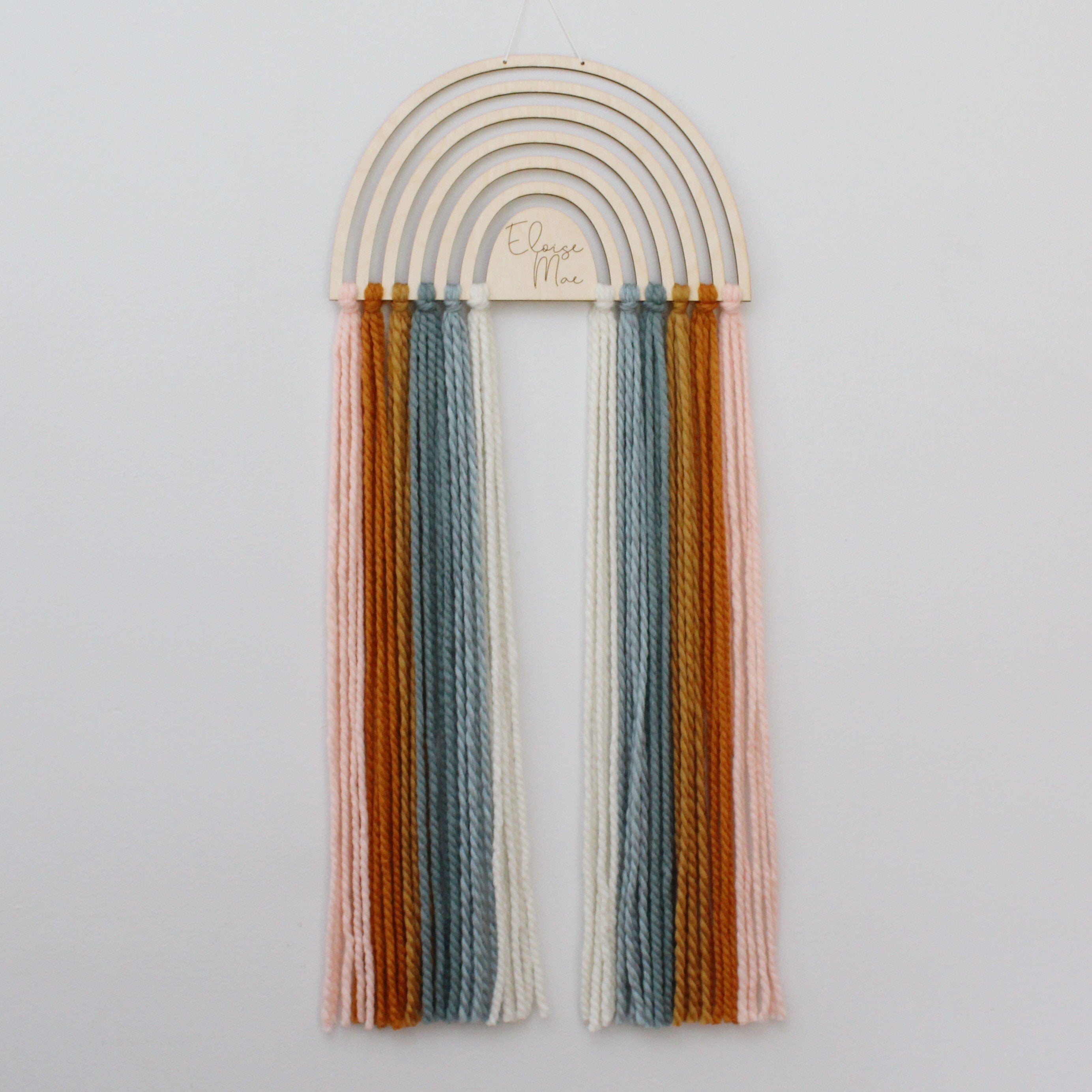 personalized wood and yarn rainbow wall hanging