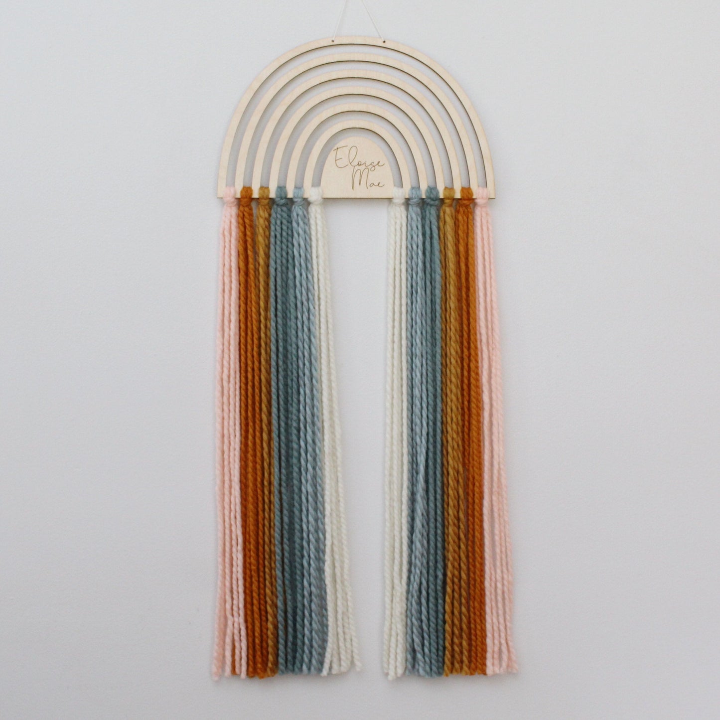 personalized wood and yarn rainbow wall hanging