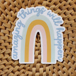 load image into gallery viewer, rainbow vinyl sticker in light blue, mustard, and pink with the words amazing things will happen in blue cursive text
