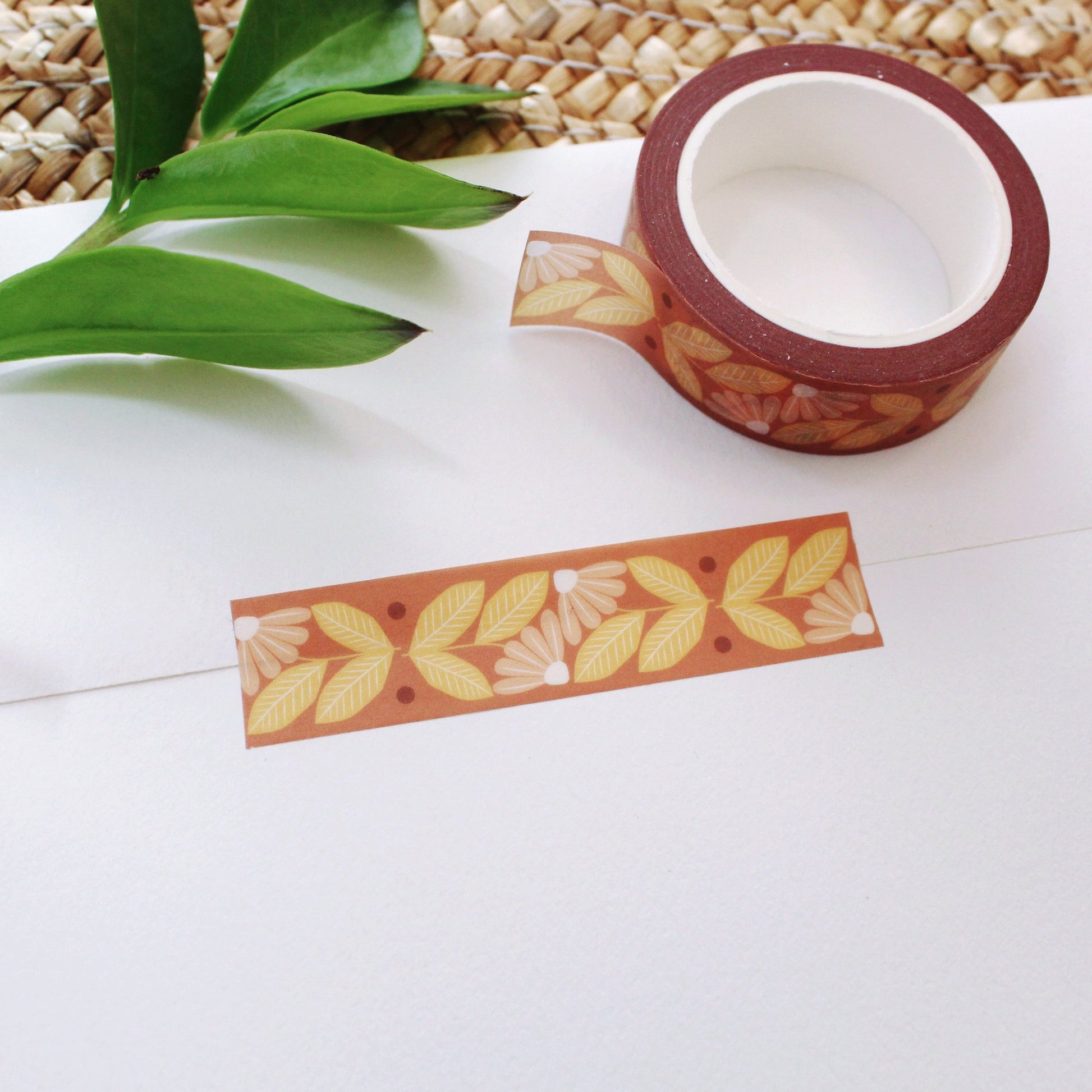 peach and yellow flower washi tape on a rust colored background.